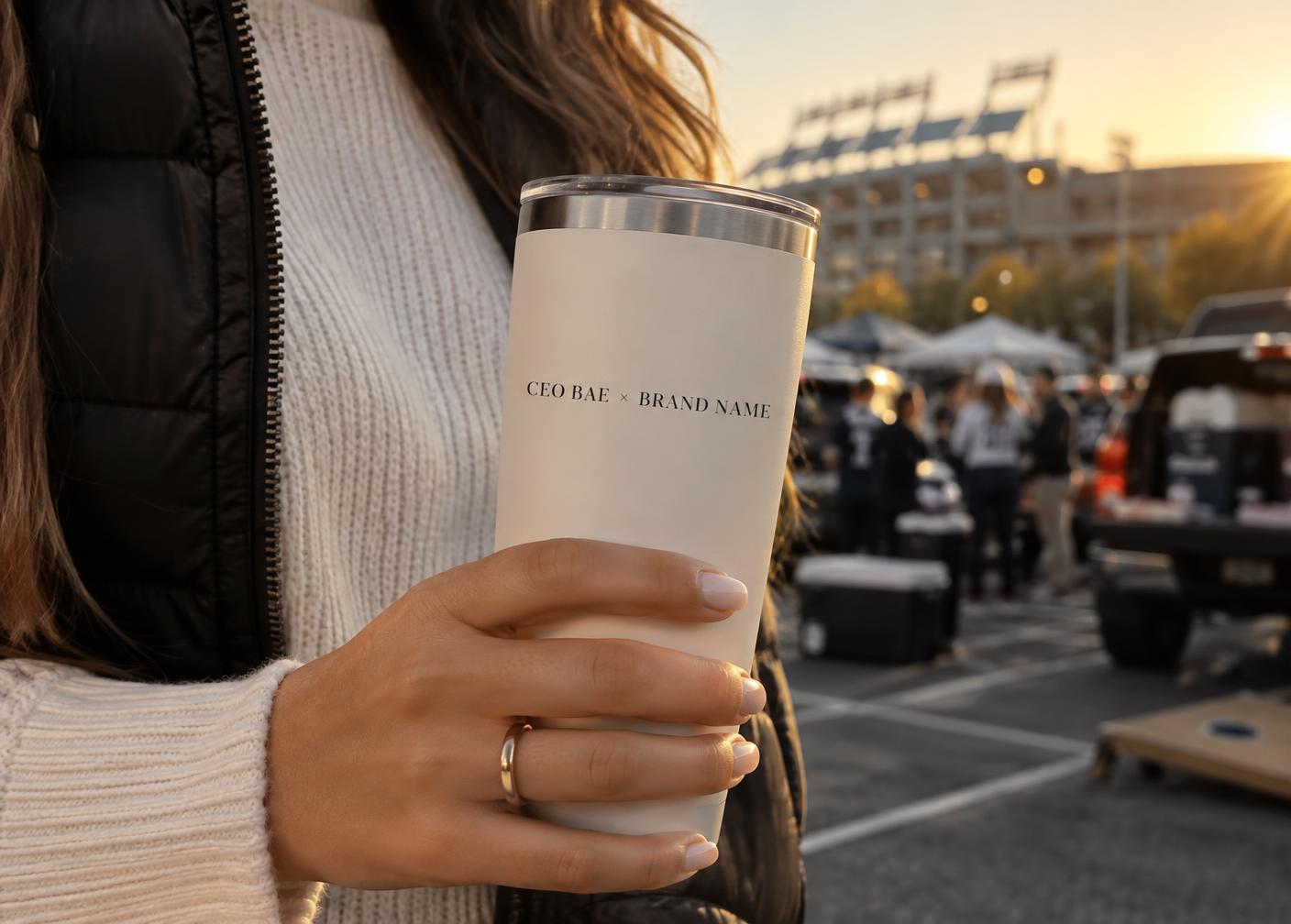 Hand holding a tumbler reading CEO BAE × BRAND NAME